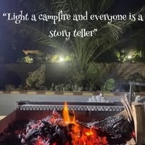 Campfire glowing at WildWind resort at night with an inspirational quote