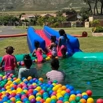 Kids sliding into a colourful ball pool at WildWind resort event
