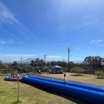 Kids on a giant slip-and-slide inflatable at WildWind resort with mountain views