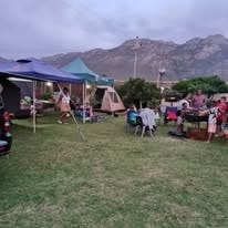 Families camping at WildWind in the evening with tents, gazebos and mountain views