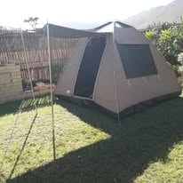Canvas tent pitched on the WildWind resort lawn with mountain views