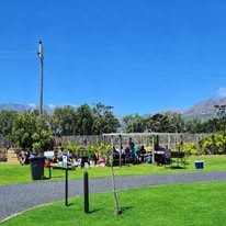 Wide open lawn at WildWind resort with mature trees and mountain backdrop