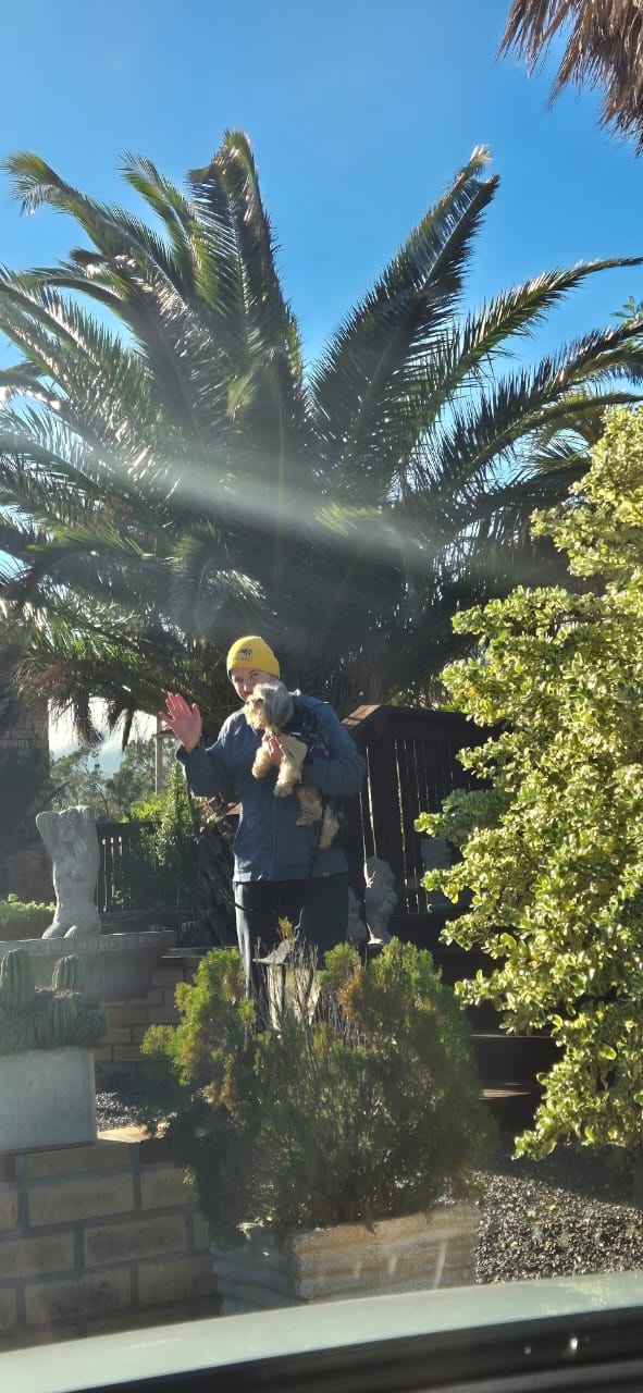 Friendly welcome at WildWind resort entrance with palm trees and lush garden