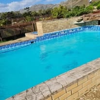 WildWind crystal-blue pool on a clear sunny day with mountain views
