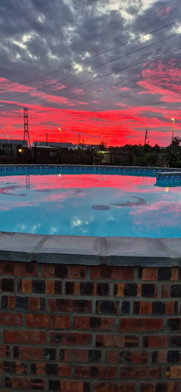 WildWind pool reflecting a dramatic crimson and red sunset sky